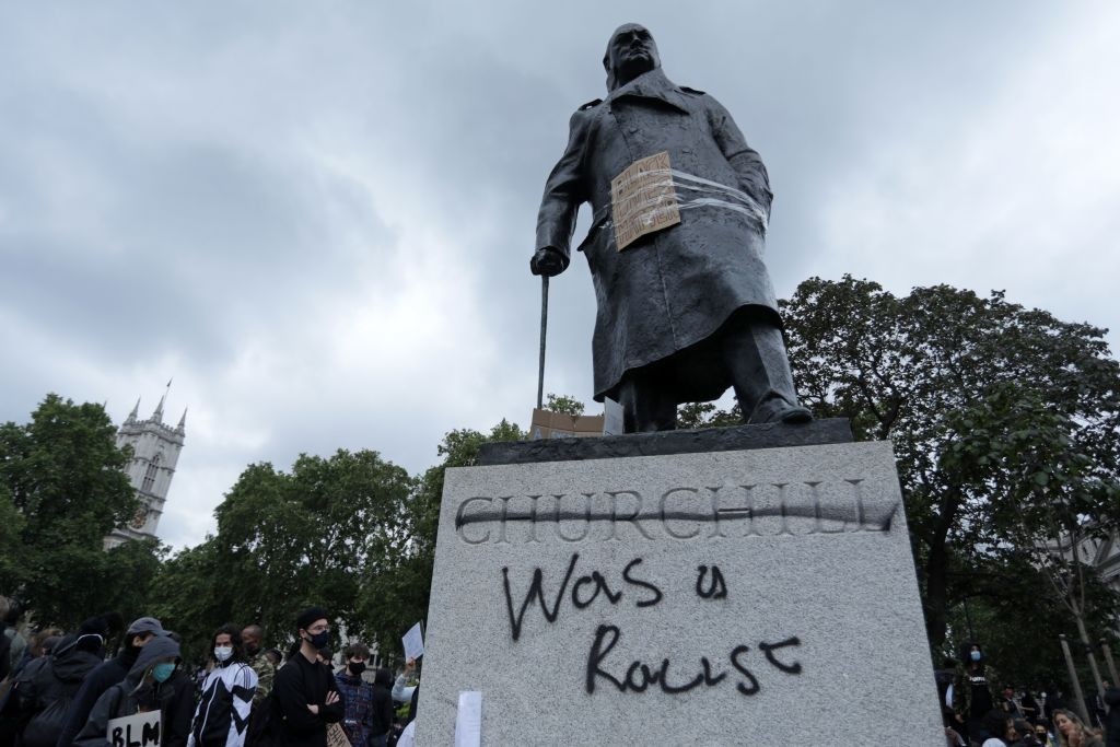 The statue of former British prime minister Winston Churchill is seen defaced, with the words (Churchill) "was a racist" written on it's base in Parliament Square, central London after a demonstration outside the US Embassy, on June 7, 2020, organised to show solidarity with the Black Lives Matter movement in the wake of the killing of George Floyd, an unarmed black man who died after a police officer knelt on his neck in Minneapolis. - Taking a knee, banging drums and ignoring social distancing measures, outraged protesters from Sydney to London on Saturday kicked off a weekend of global rallies against racism and police brutality. (Photo by ISABEL INFANTES / AFP) (Photo by ISABEL INFANTES/AFP via Getty Images)