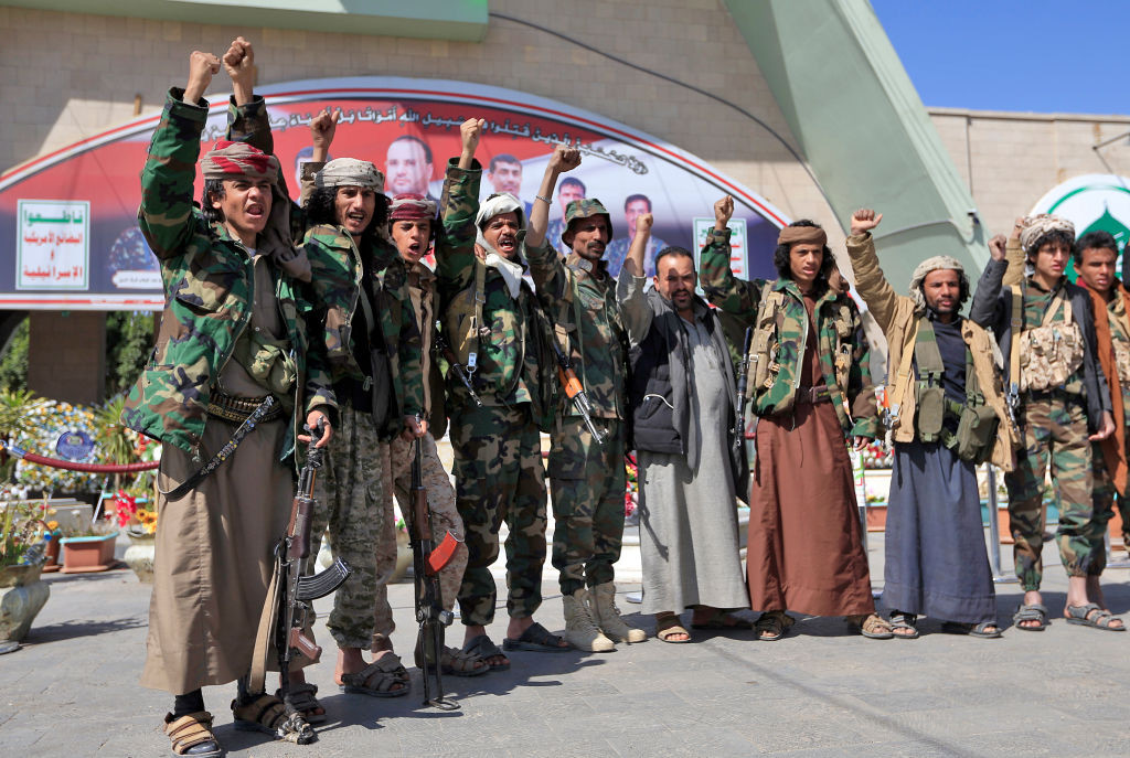 Fighters loyal to Yemen's Huthi rebels raise their fists and chant slogans as they visit the grave of slain Huthi political leader Saleh al-Sammad at al-Sabeen square in the capital Sanaa, on January 11, 2021. - In April 2018, al-Sammad, who was on the Saudi-led coalition's wanted list, was killed in what the insurgents said was an air strike by the coalition. (Photo by Mohammed HUWAIS / AFP) (Photo by MOHAMMED HUWAIS/AFP via Getty Images)