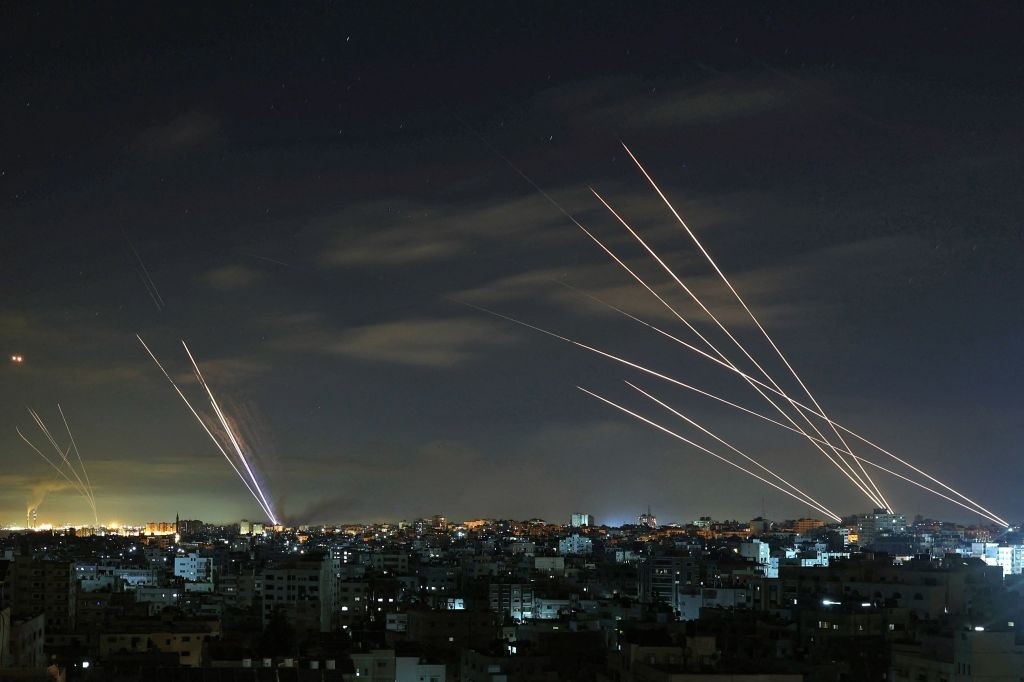 Israel's Iron Dome missile defence system (L) intercepts rockets (R) fired by the Hamas movement from Gaza city towards Israel early on May 16, 2021. - Israel pummelled the Gaza Strip with air strikes, killing 10 members of an extended family and demolishing a building housing international media outlets, as Palestinian militants fired back barrages of rockets. (Photo by MOHAMMED ABED / AFP) (Photo by MOHAMMED ABED/AFP via Getty Images)