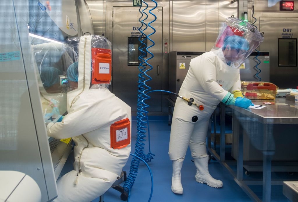 Workers are seen next to a cage with mice (R) inside the P4 laboratory in Wuhan, capital of China's Hubei province, on February 23, 2017. - The P4 epidemiological laboratory was built in co-operation with French bio-industrial firm Institut Merieux and the Chinese Academy of Sciences. (Photo by Johannes EISELE / AFP) (Photo by JOHANNES EISELE/AFP via Getty Images)