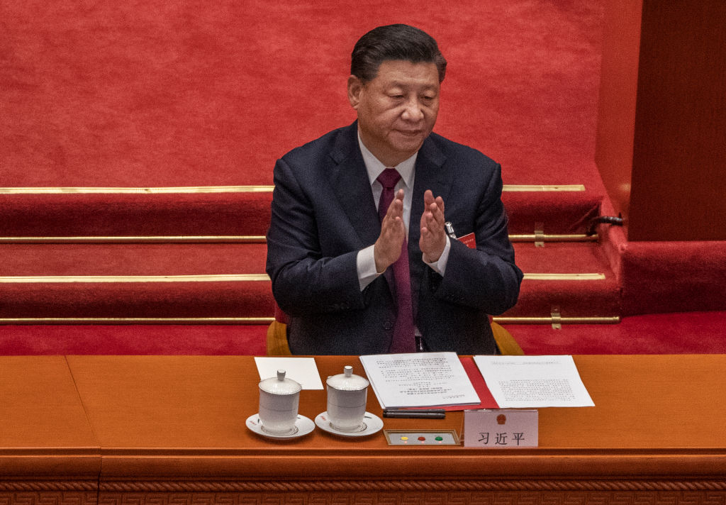 BEIJING, CHINA - MARCH 11: China's President Xi Jinping applauds after voting during a session that also included a vote in favour of a resolution to overhaul Hong Kong's electoral system, during the closing session of the National People's Congress at the Great Hall of the People on March 11, 2021 in Beijing, China. The annual political gatherings of the National People's Congress and the Chinese People's Political Consultative Conference, known as the Two Sessions, brings together China's leadership and lawmakers to set the blueprint for the coming year. It is considered the most important event on the governments calendar and offers a rare glimpse at what President Xi Jinping and top officials see as priorities. With the pandemic largely under control in China, discussions this year are expected to signal Beijing's intentions around technology competition, control over Hong Kong, and strategic threats posed by Western countries including the United States. The political meetings, held at the Great Hall of the People at the edge of Tiananmen Square in central Beijing, can typically last for up to two weeks. (Photo by Kevin Frayer/Getty Images)