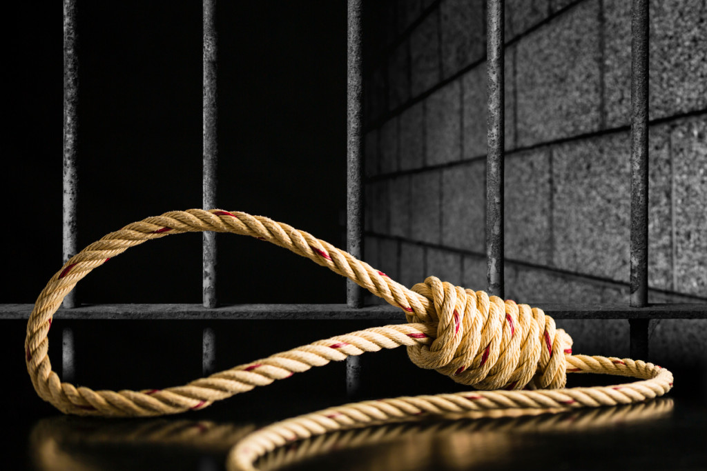 Brown rope noose dark and light on black table with old prison bars cell lock background dark black and light, concept of punishment